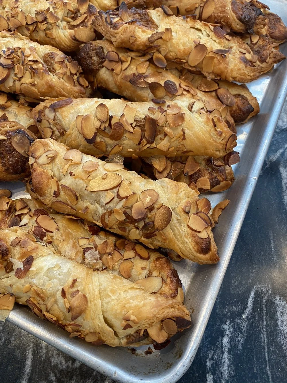 A tray of almond-crusted pastry twists from the bakery